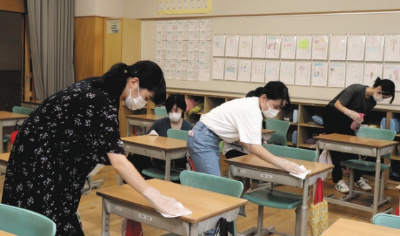 手際よく教室内の消毒作業を進める学生ら＝山県市の高富小で