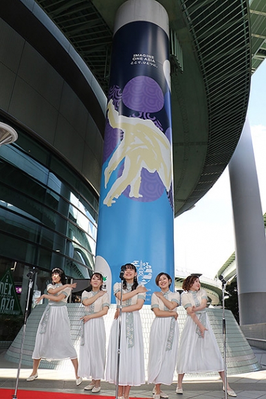 公社設立50周年記念で橋脚に施されたラッピングアート。手前は、公社のイメージソングを歌う名古屋芸術大生ら=北区清水で