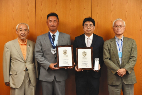 青山市長（左）に受賞を報告した（右から）長野学長、簗瀬学生支援部長、高柳監督＝中津川市役所で