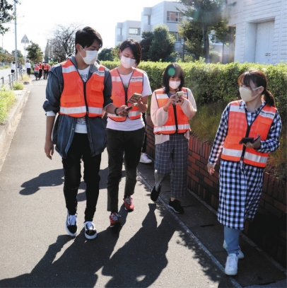 防犯アプリを使いながら、大学周辺を巡回する学生＝瑞穂市で