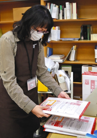 蔵書や資料の郵送貸し出しの作業をする職員＝日進市の名古屋外国語大・名古屋学芸大図書館で