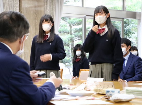 地元商店街と共同で開発した商品の説明をする半田商高の生徒ら＝県公館で