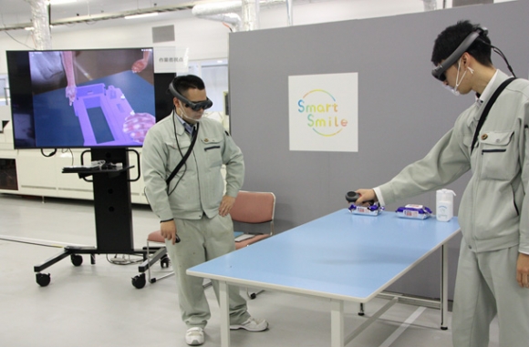 ウエアラブル端末に映る３Ｄデータを見ながら遠隔地との打ち合わせをする従業員＝金沢市の北菱電興いなほ工場で