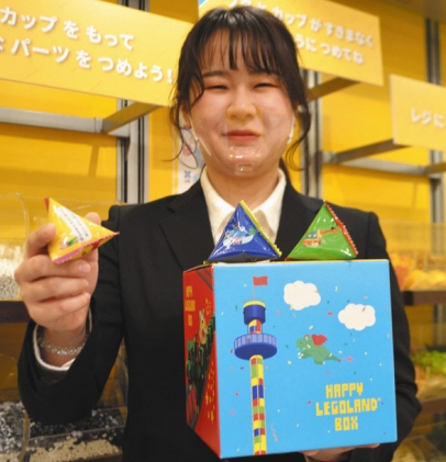 企画開発した「ハッピーレゴランドボックス」を手にする鈴木さん＝名古屋市港区のレゴランドで