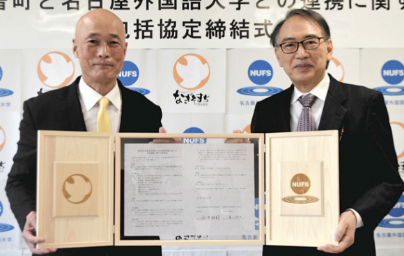 協定書を持つ亀山学長(右)と向井町長=日進市の名古屋外国語大で