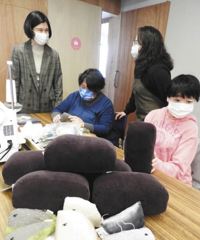 石垣のぬいぐるみの商品化を、「モーヤーコ」の利用者たちと喜び合う森島さん(左)=北区志賀南通2で