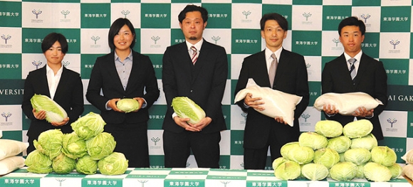 贈呈式で農産物を受け取る学生ら＝みよし市の東海学園大で