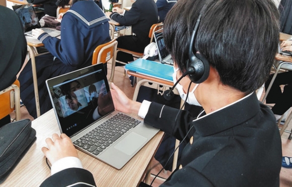 オンラインで大学生と英会話する生徒＝中区の丸の内中で