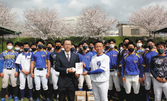 志門塾からボールを贈られた岐阜聖徳学園大野球部員ら＝岐阜市柳津町で