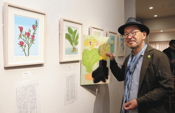 制作に使った木版を手に持って作品を紹介する高北さん＝美濃市段町の風のいえ～かねまつさんち～で