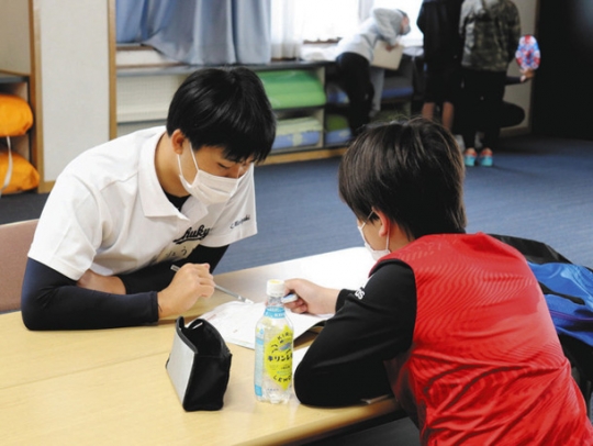 児童に勉強を教える学生（左）＝いずれも豊田市豊栄町で