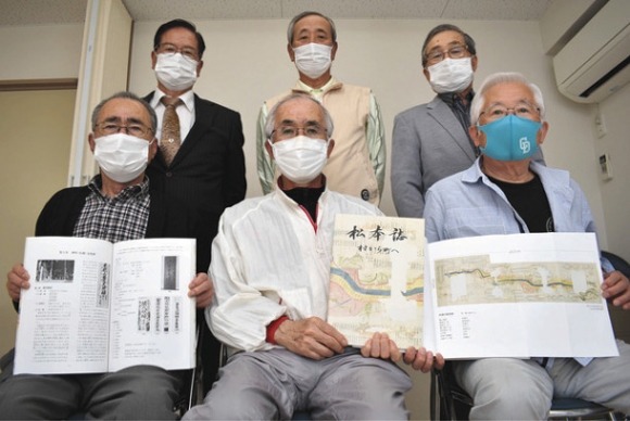郷土誌「松本誌　村から町へ」を手にする編さん委員ら＝春日井市松本町の松本公民館で