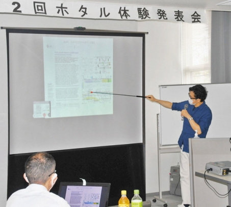 ホタル体験発表会で講演する大場教授（右）＝福井市の県国際交流会館で