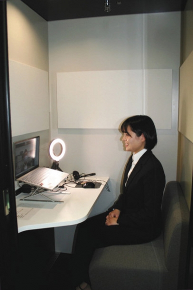 個室型ワークスペースで、大学の担当者に面接での画面の映り方を確認してもらう神谷さん＝千種区の椙山女学園大で