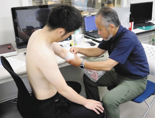 発汗量を計測する松本教授(右)=豊田市貝津町の中京大豊田キャンパスで