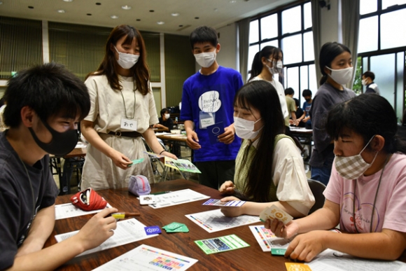 ゲーム中に手元のカードを見ながら、どのプロジェクトを実施するか選ぶ子どもたち＝大府市で