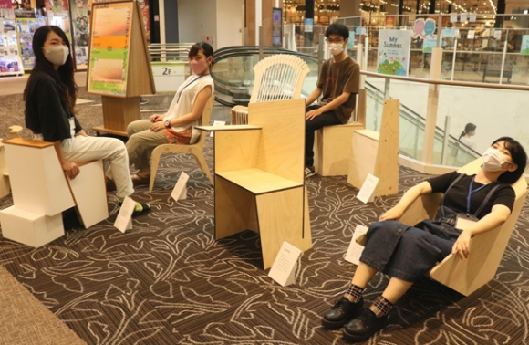 アイデアが凝らされたいすに座る学生=長久手市のイオンモール長久手で