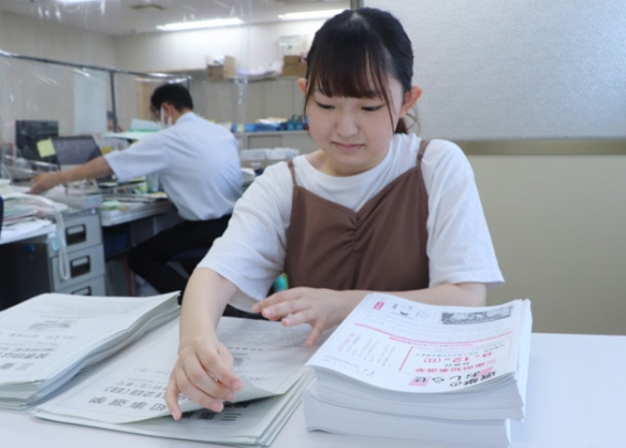 選挙公報の部数を数える前田さん=伊勢市役所内の選管事務局で