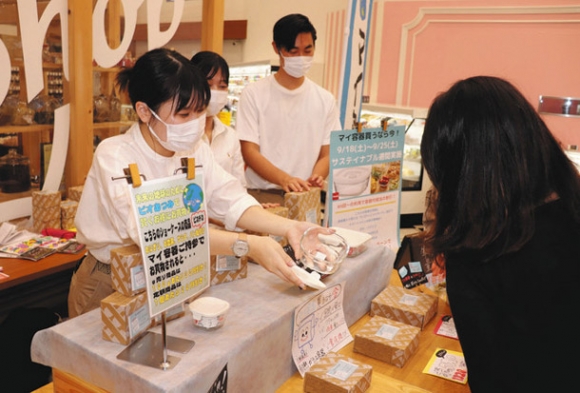 マイ容器を販売する南山大の学生たち＝豊橋市三ノ輪町で