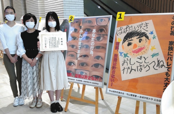 痴漢や盗撮防止を呼び掛けるポスターを制作した学生たち＝守山区の金城学院大で