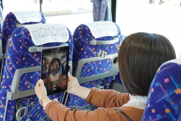 バスの車内で顔認証登録を実演する関係者=白山市三宮町で