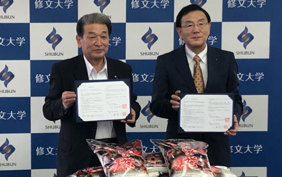 協定書に署名した勝野町長(左)と丹羽学長=愛知県一宮市で