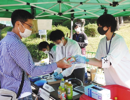 デポジットを上乗せしたペットボトル飲料を販売する学生（右）ら＝千種区の東山動物園で