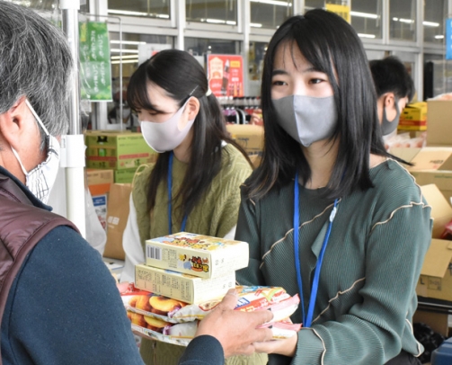 地域住民から食料品を受け取る学生ら=北名古屋市弥勒寺西のピアゴ西春店で