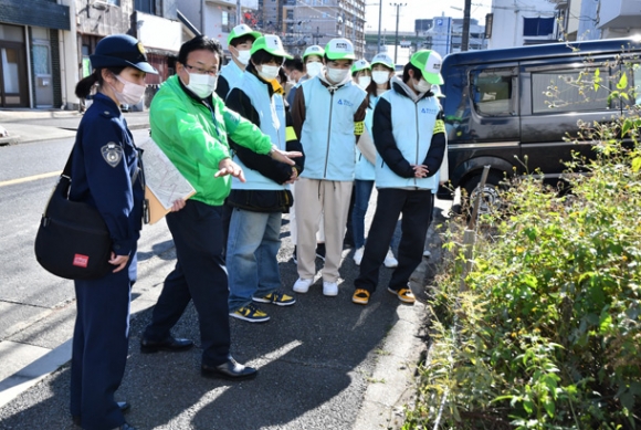 不審者が出入りしやすく、周りから見えにくい場所について説明する野口さん(左から2人目)=中村区下米野町1で