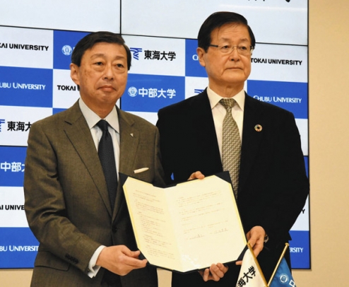 協定書を披露する中部大の竹内学長（右）と東海大の山田学長＝春日井市の中部大で