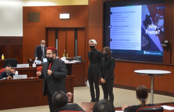 「回転チーズレストラン」のビジネスプランを発表するフランス人留学生たち＝日進市の名古屋商科大で