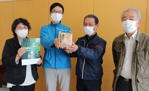 竹粉を活用してできた米をＰＲする研究会のメンバー＝四日市市萱生町の四日市大で（片山さゆみ撮影）