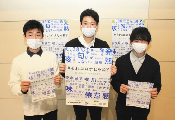 「ポスターをきっかけに若者にコロナへの備えをしっかりしてもらえたら」と話すナンザンエイドのメンバー＝市役所で