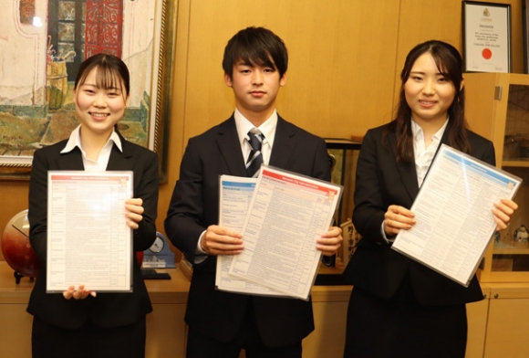 英語のパンフレットを作製した学生たち=野々市市役所で