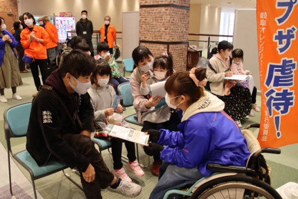 ボランティアスタッフらと話す親子＝岐阜市柳津町丸野のカラフルタウン岐阜で