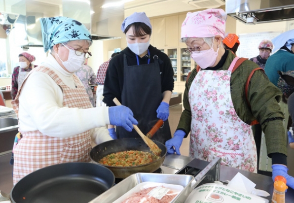 学生（中）の指示に沿ってカレーを作る参加者＝東区代官町のＪＡなごや本店で