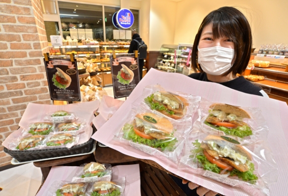 販売が始まったサンドイッチを紹介する名市大の牧さん＝中区のヴィ・ド・フランス上前津店で