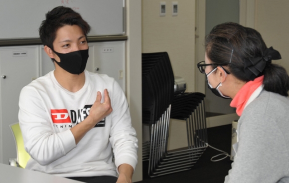 「大丈夫ですか？」の手話を越智准教授に見せる高橋さん（左）＝大府市の至学館大で