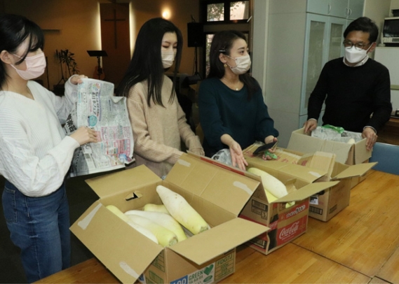 尾張旭市内の子ども食堂にダイコンを届ける学生たち＝尾張旭市柏井町のパークサイド食堂で