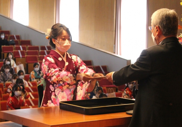 曽根学長（右）から卒業証書を受け取る卒業生＝大垣市の大垣女子短大で