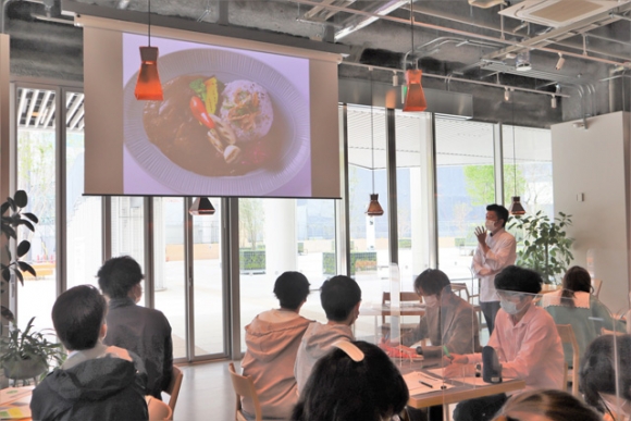 今里総料理長(右奥)の講義を聴く学生ら=豊橋市駅前大通のエムキャンパスで