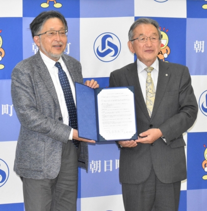 締結書に署名した矢野町長（右）と岩崎学長＝朝日町役場で