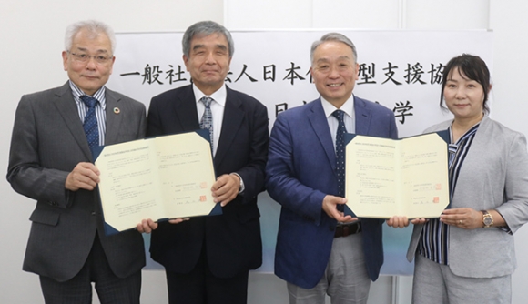 協定書を手にする奥田理事（右から２人目）ら出席者＝東海市の日本福祉大東海キャンパスで