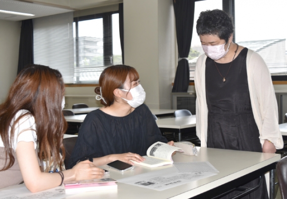 抗がん剤治療などの経験を教材にしてがん教育をする嶋守教授（右）＝豊明市の桜花学園大で