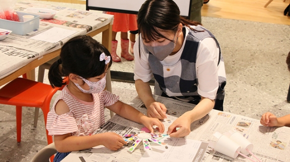 おもちゃの作り方を教える学生＝豊橋市駅前大通のまちなか図書館で