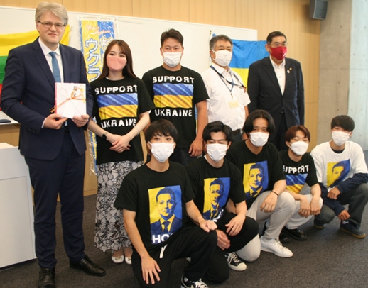 募金活動に参加した学生と稲葉教授（後列右から２人目）から目録を受け取ったジーカス大使（左）ら＝２０日、名古屋市東区の名城大で