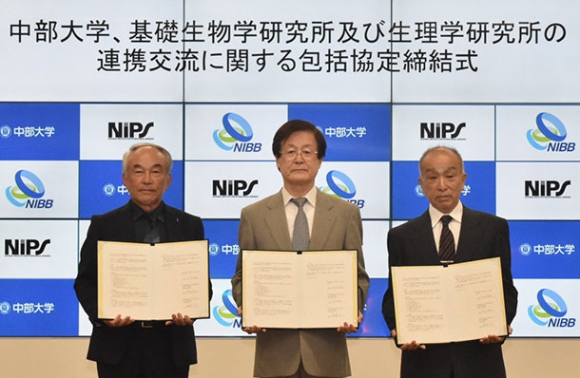 それぞれ協定書を手にする（左から）阿形所長と竹内学長、鍋倉所長＝春日井市松本町の中部大で