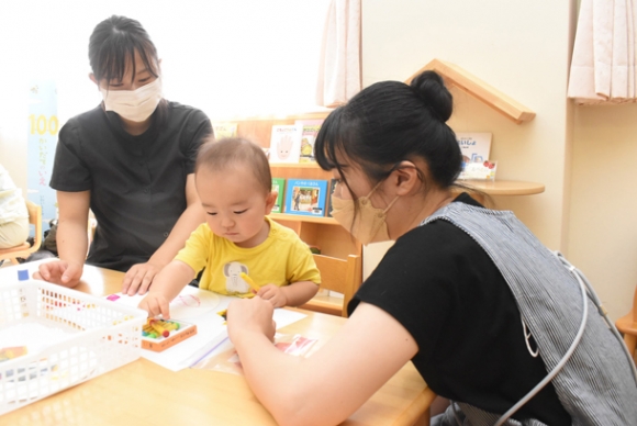 学生(右)と工作体験をする子ども(中央)=岡崎市中町の岡崎女子大・短大で