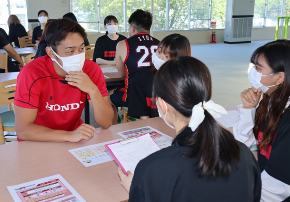 三重ホンダヒートの選手（左）と栄養面について意見交換する学生＝鈴鹿市住吉町のホンダアクティブランドで