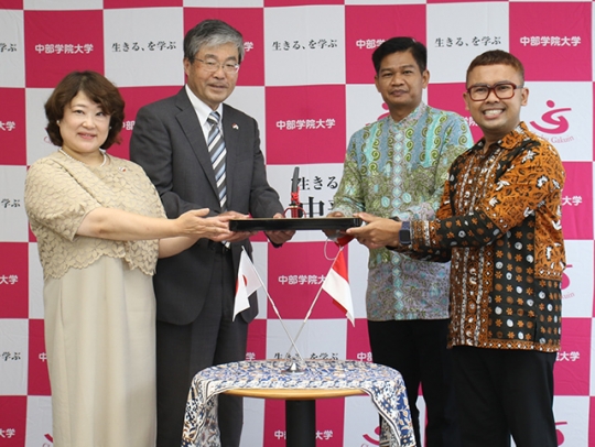 友好の印に関のはさみを受け取るアヨ局長（右から２人目）ら＝関市桐ケ丘の中部学院大で